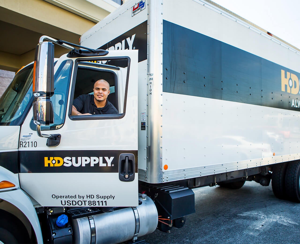 Parked HD Supply truck with a smiling driver inside