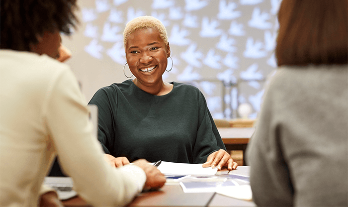 Woman laughing during meeting with colleagues