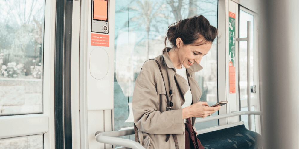 Woman checks her phone on a train.