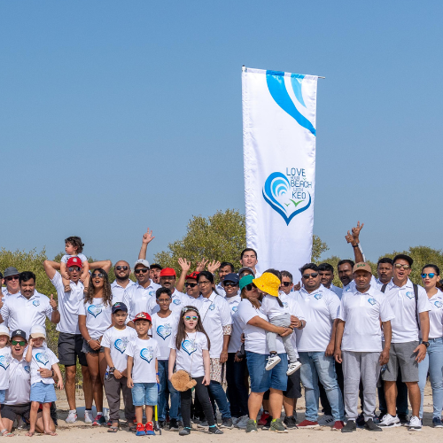 KEO employees and their families pose for a group photo at the beach